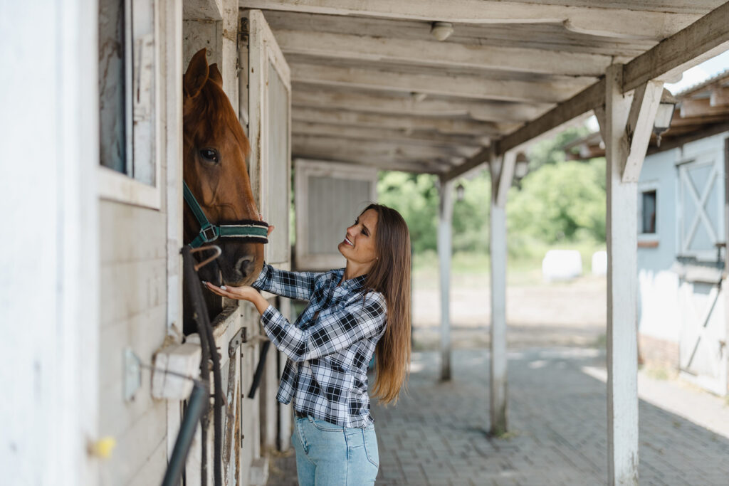 Young woman in a stable with her horse - Landmark Chiropractic
